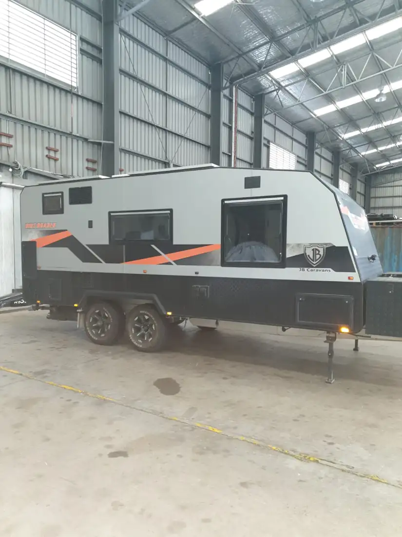 Off-road caravan under cover in a shed before shipping
