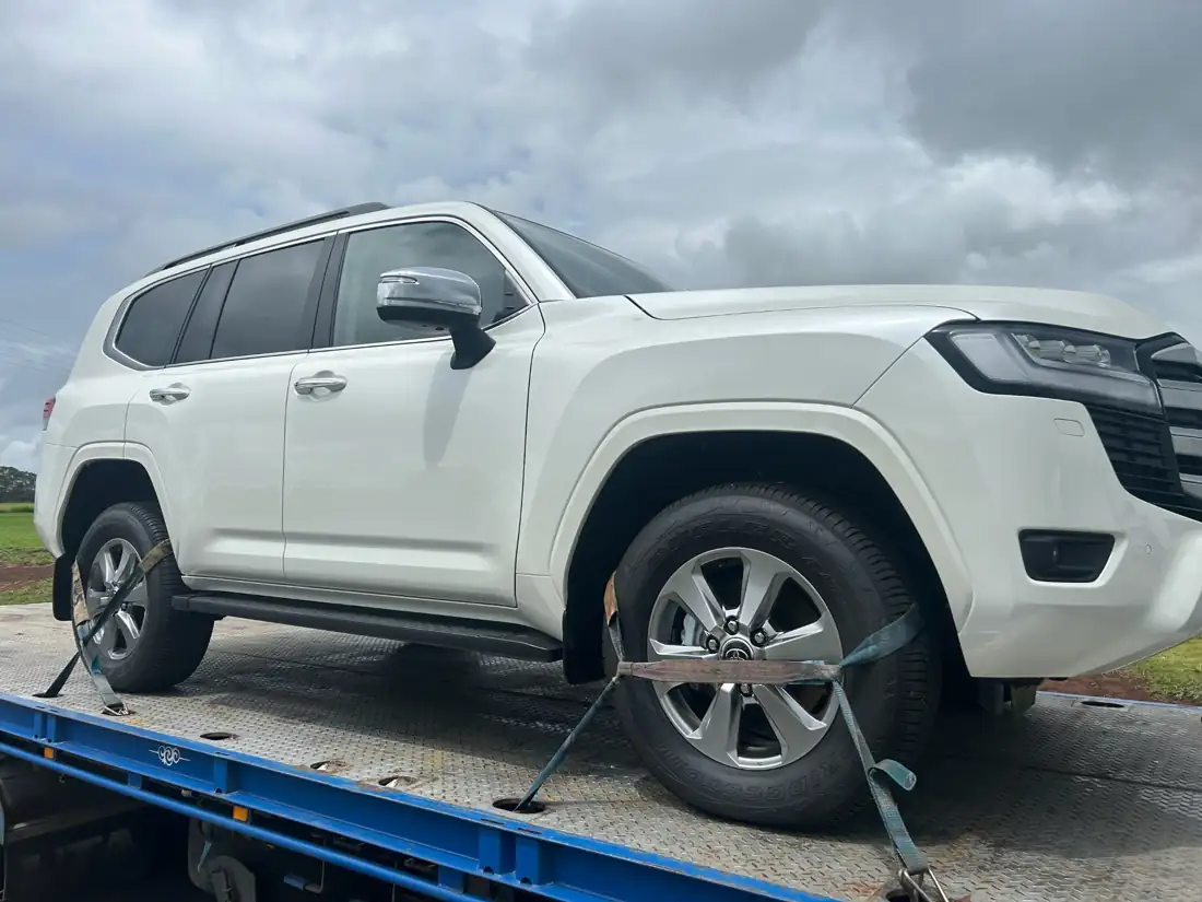 Toyota LandCruiser 300 strapped to a tow truck on its way to the port