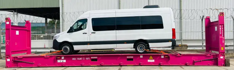 Passenger van lashed onto a flat rack container at the wharf